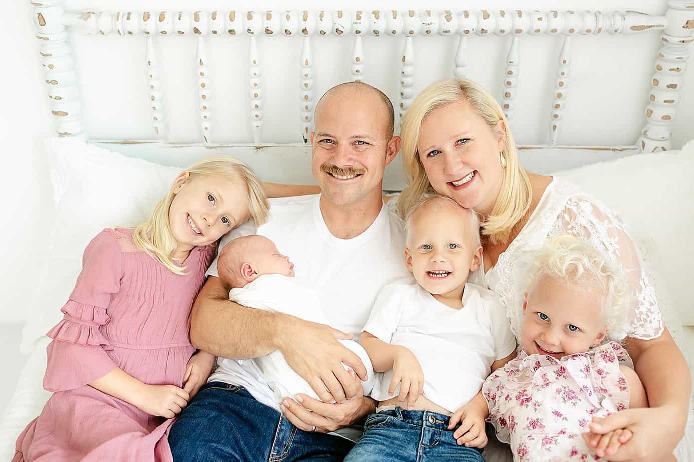 Family with 4 children on a bed during their pensacola photography session