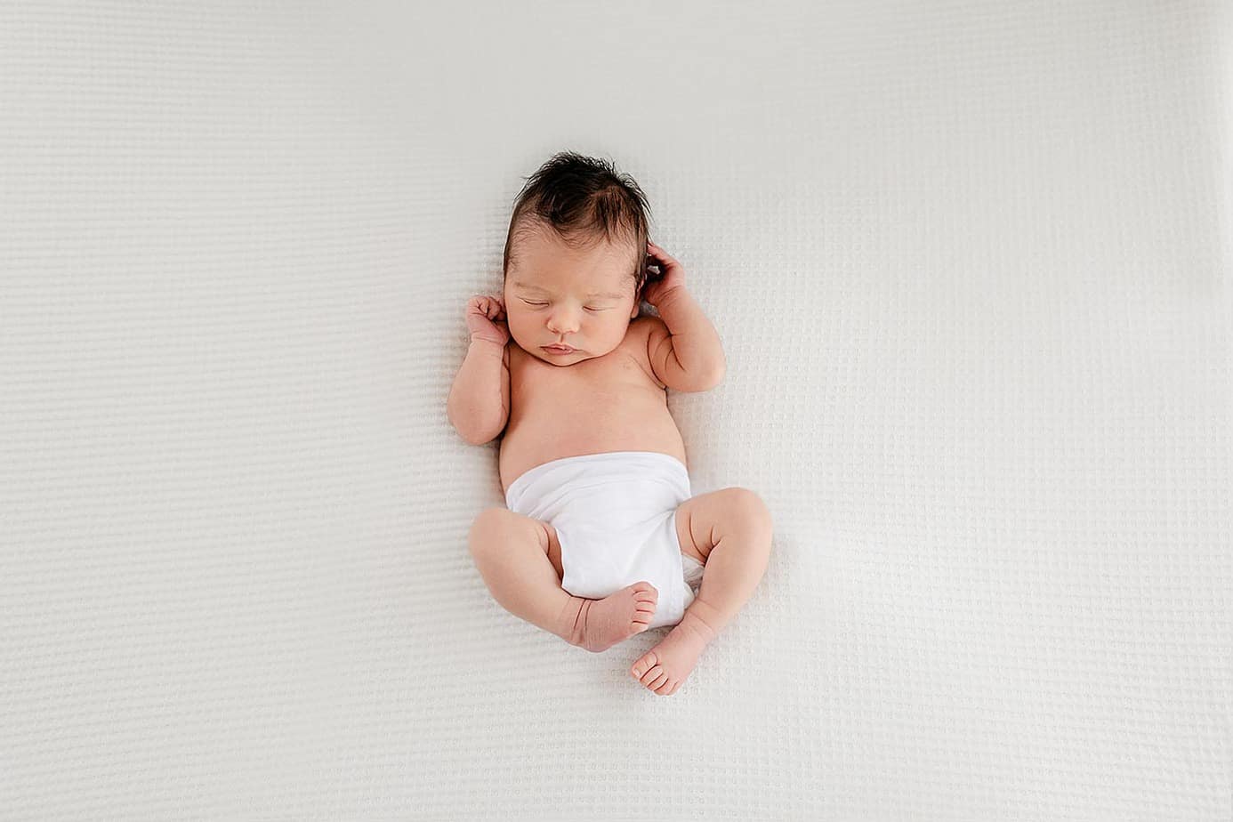 Newborn baby girl on white in pensacola photography studio