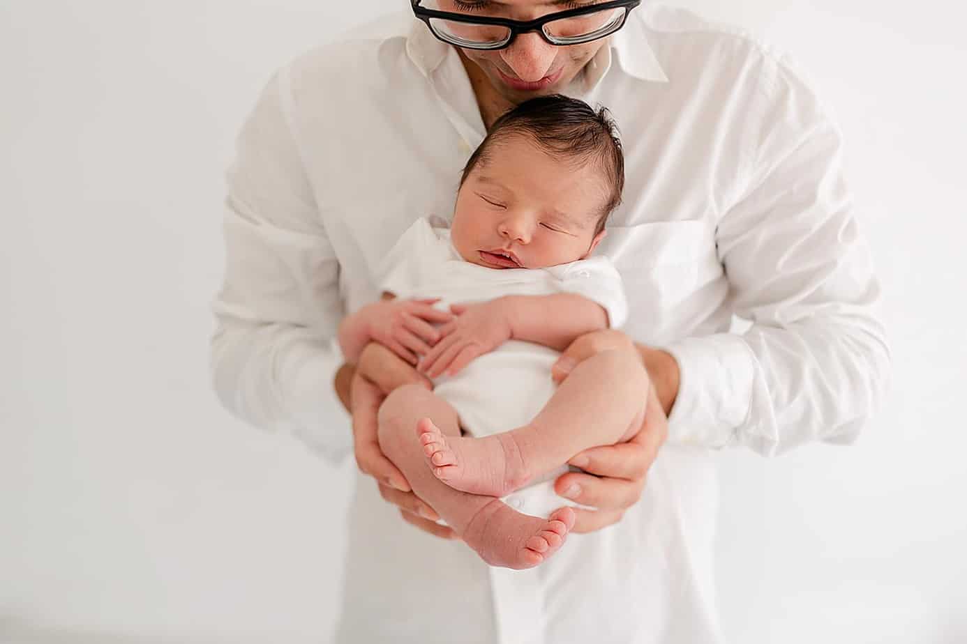 newborn being held by dad pensacola photographer